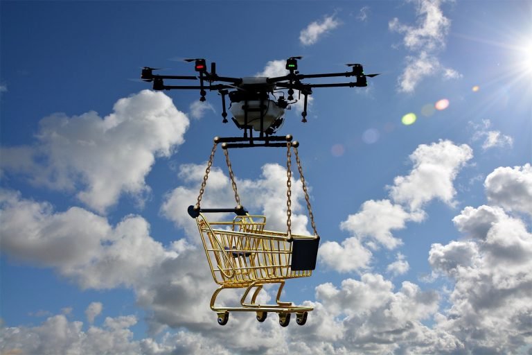 Drone draagt een winkelwagentje door een blauwe lucht met wolken
