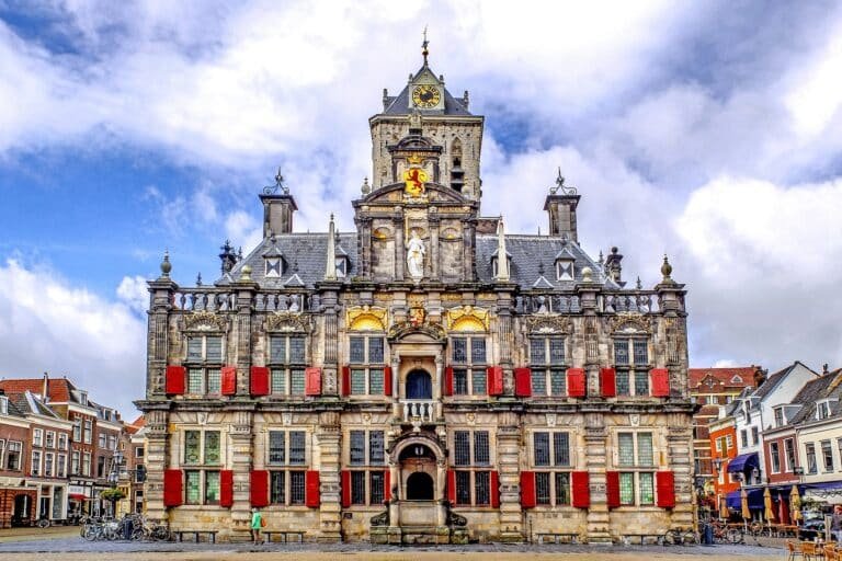 Stadhuis van Delft op de Markt onder een blauwe lucht met wolken
