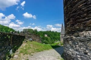 Oude stenen muur en toren van een kasteel boven een groene heuvel in de Ardennen