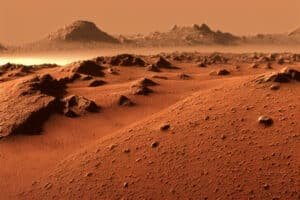 Rood, stoffig landschap op Mars met duinen en losse stenen