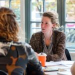 Vrouw die het woord heeft aan tafel