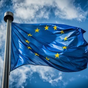 Vlag van de Europese Unie wappert aan een mast tegen een blauwe lucht