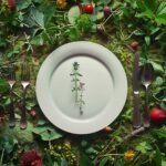 Bord met enkele plantjes en planten fruit en groente er omheen