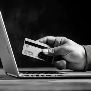 Hand met creditcard bij laptop