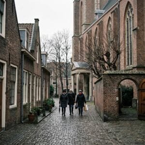 Smalle steeg met lage bakstenen huisjes naast de Pieterskerk in Leiden op een grijze novemberochtend
